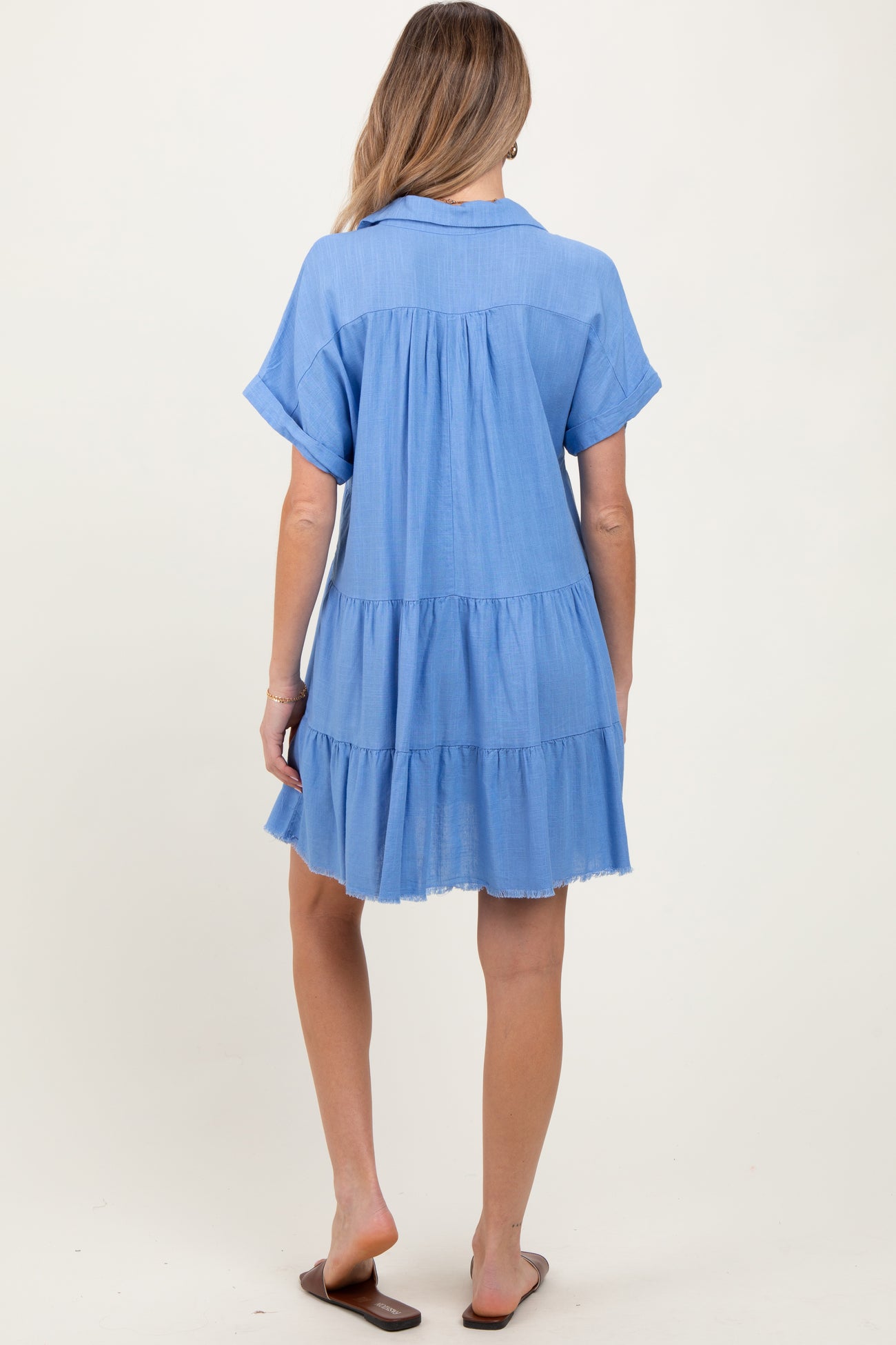 woman wearing a light blue short sleeve maternity dress with tiered detailing and a relaxed fit from the back