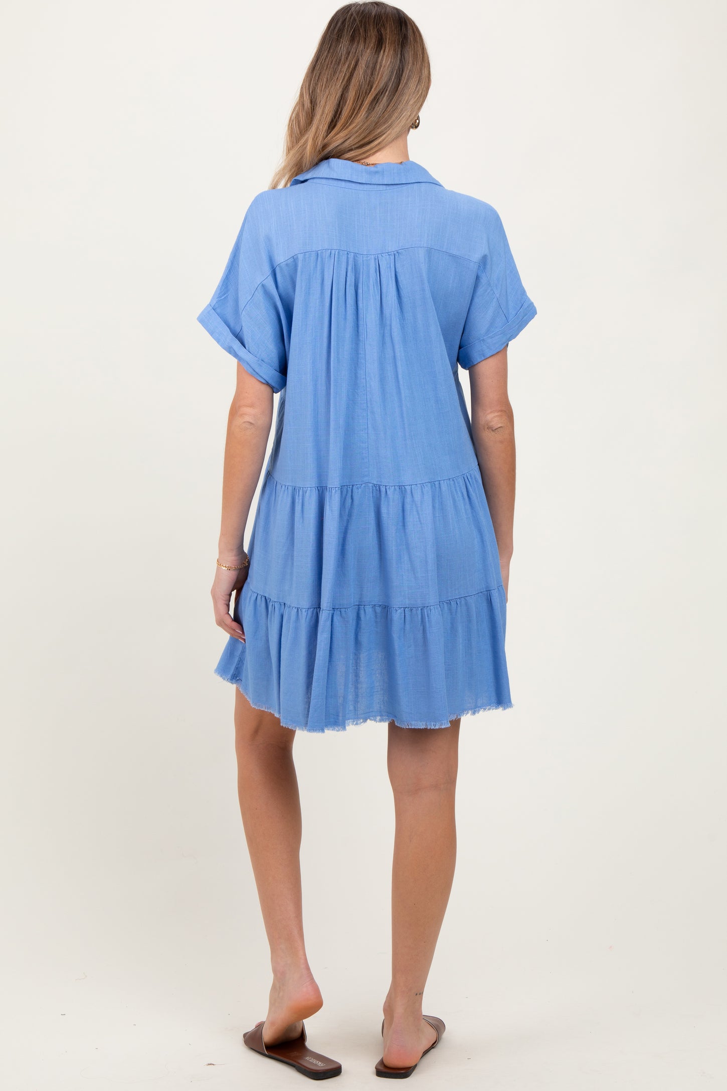 woman wearing a light blue short sleeve maternity dress with tiered detailing and a relaxed fit from the back