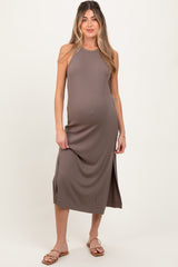 woman wearing a brown sleeveless maternity dress with side slits and a visible baby bump