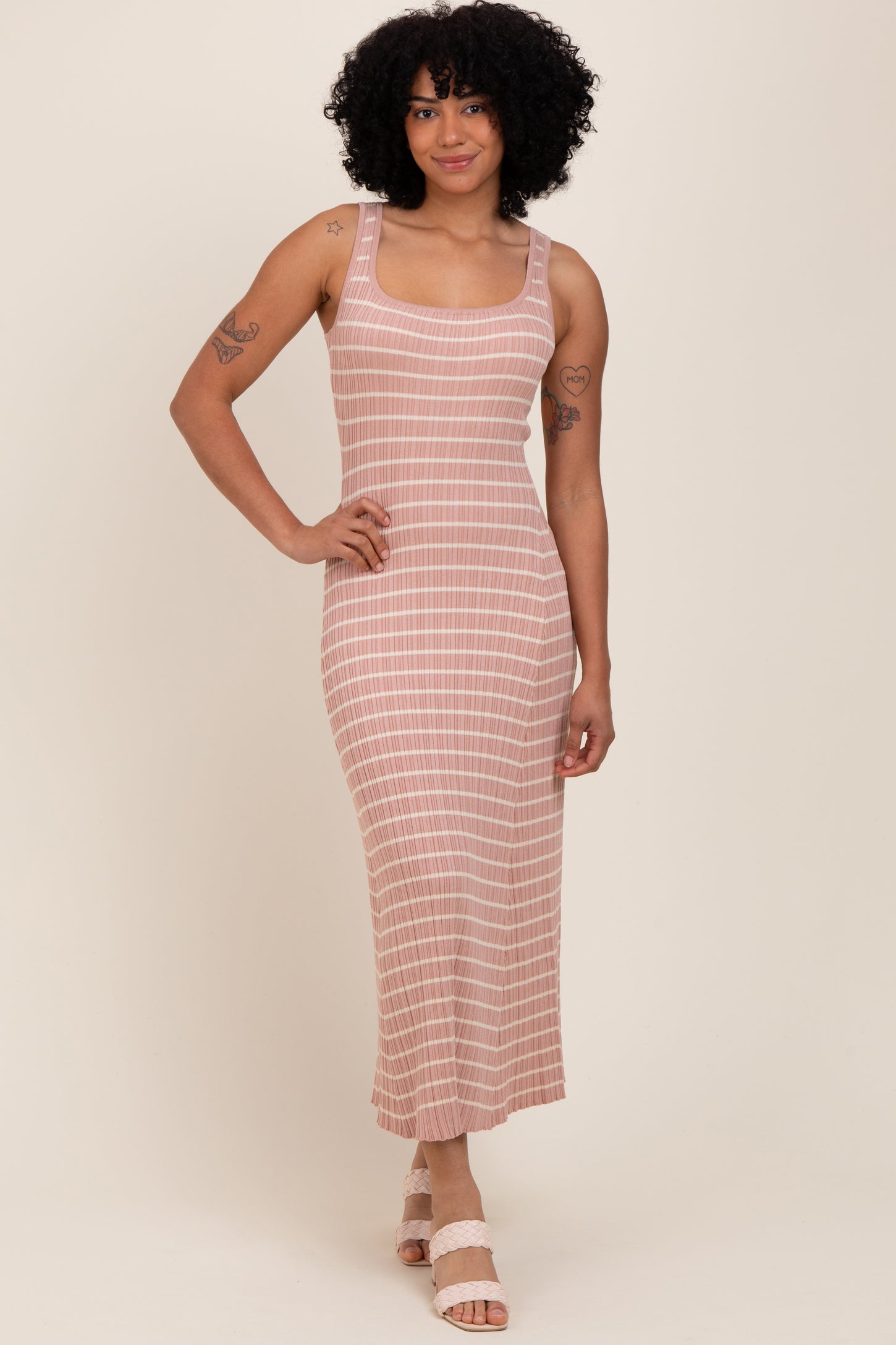 woman wearing a mauve striped sleeveless midi dress with a fitted silhouette and standing on a neutral background