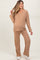 woman wearing a light brown ribbed maternity loungewear set with a v-neck top and pants, showcasing a visible baby bump