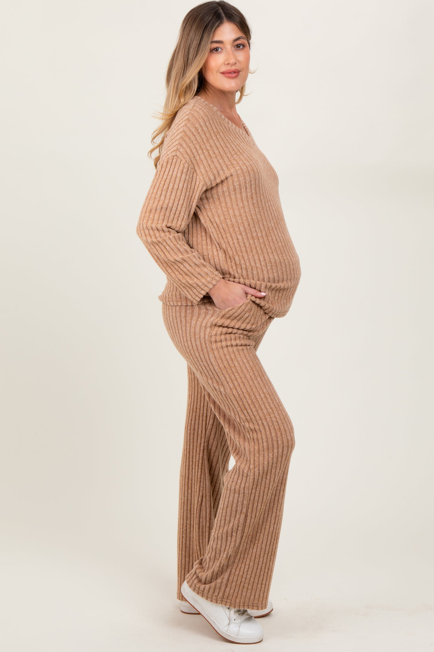 woman wearing a tan ribbed maternity loungewear set with a visible baby bump