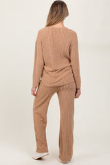woman wearing a beige ribbed maternity loungewear set consisting of a long sleeve top and matching pants