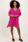 woman wearing a bright pink crochet beach cover-up with short sleeves and side slits