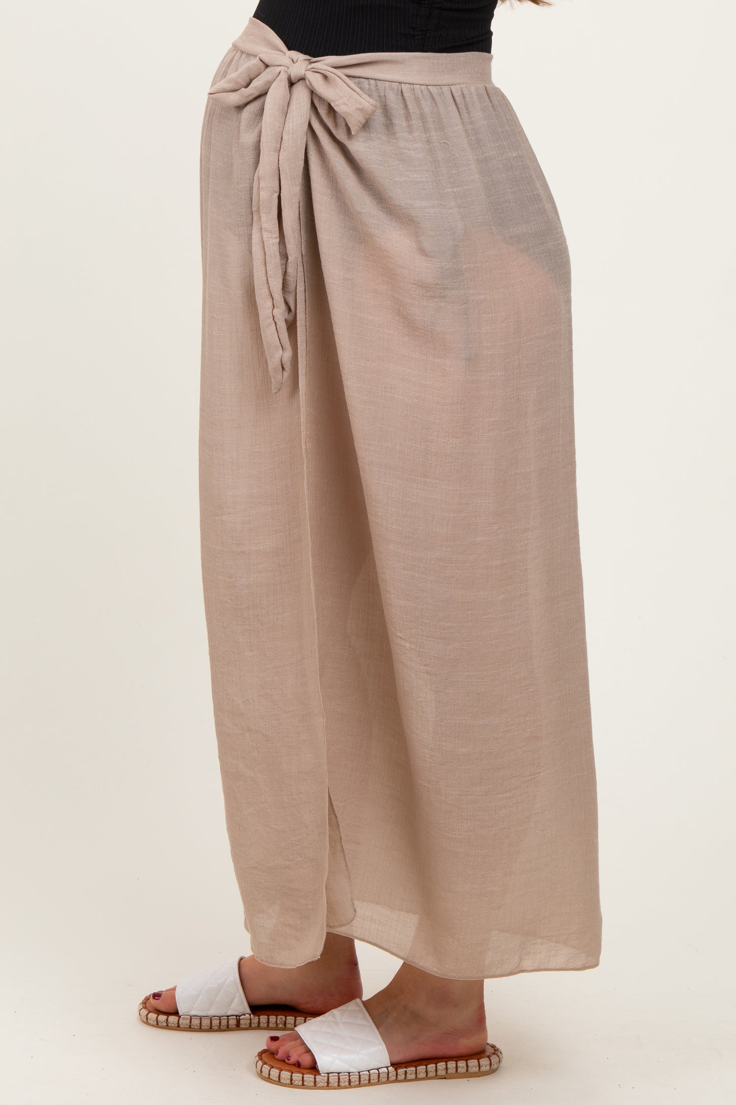woman wearing beige maternity wide-leg pants with a tie waist detail and a relaxed fit