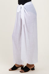 woman wearing white lightweight wide-leg pants tied at the waist with a sash, paired with black slide sandals
