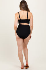 woman wearing a black ribbed maternity bikini top and high-waisted bottom, showing her back and no visible baby bump