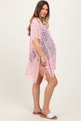 woman wearing a pink crochet maternity cover-up with a visible baby bump