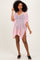 woman wearing a pink crochet cover-up with short sleeves and a v-neckline, standing and posing stylishly