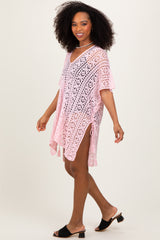 woman wearing a pink crochet cover-up with short sleeves and side slits, styled over a swimsuit