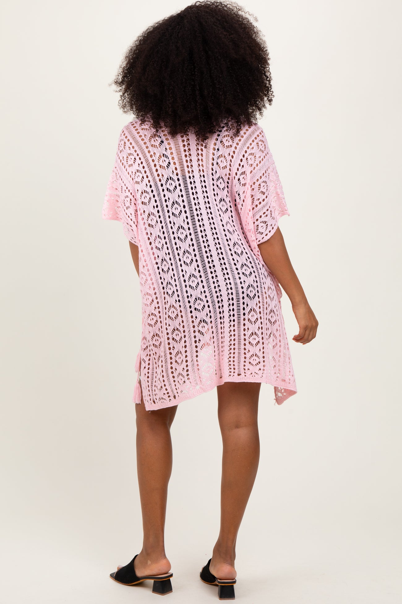 woman wearing a pink lace cover-up with a loose fit and short sleeves