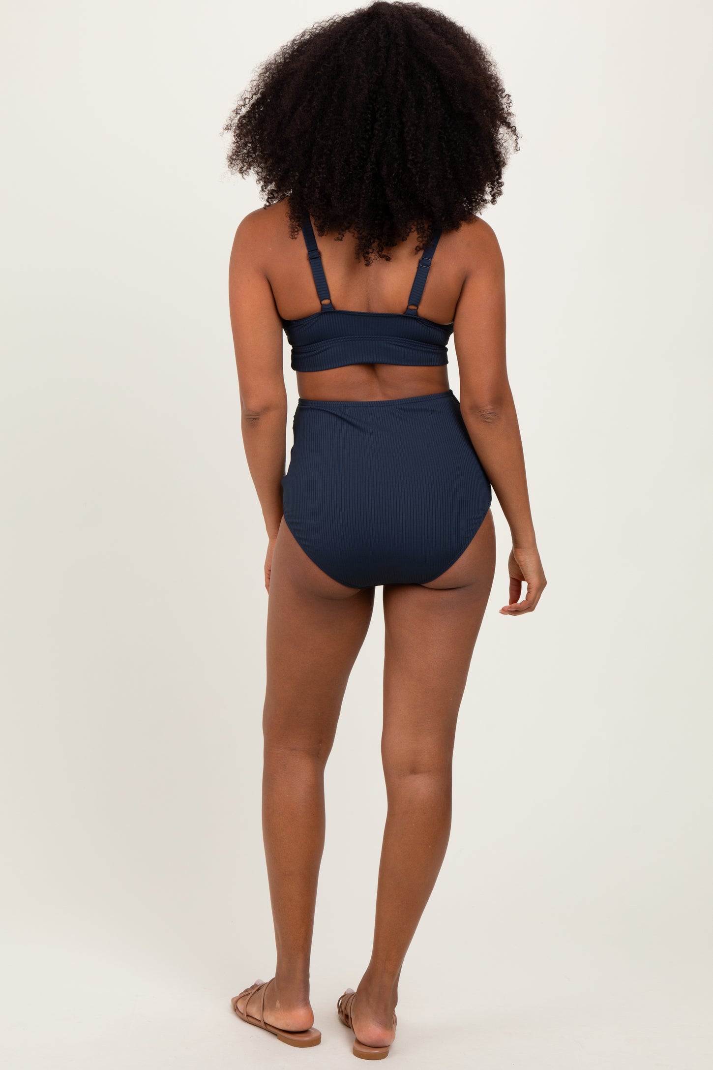 woman wearing a navy ribbed high-waisted bikini from the back with a supportive top and minimal tan lines