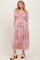 woman wearing a light pink tiered lace dress with short puff sleeves and a square neckline