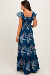 woman wearing a navy floral maternity maxi dress with a smocked bodice and flutter sleeves