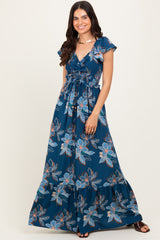 woman wearing a navy blue floral maxi dress with a v-neckline and tie waist detail
