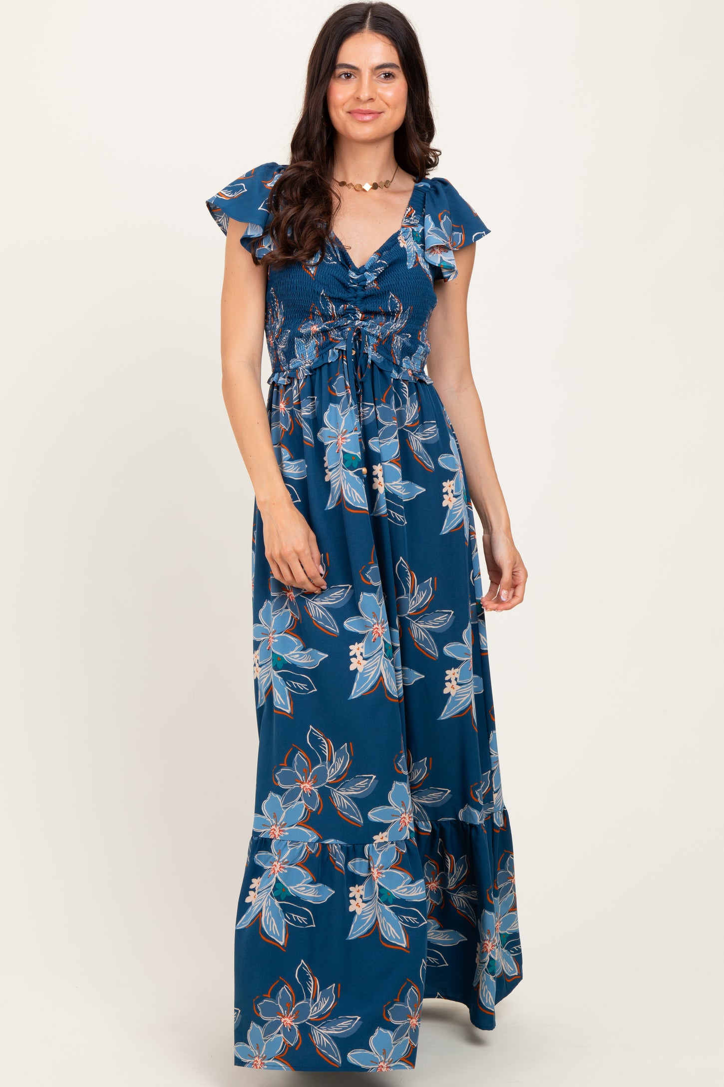 woman wearing a navy blue floral maxi dress with ruffled sleeves and a smocked bodice