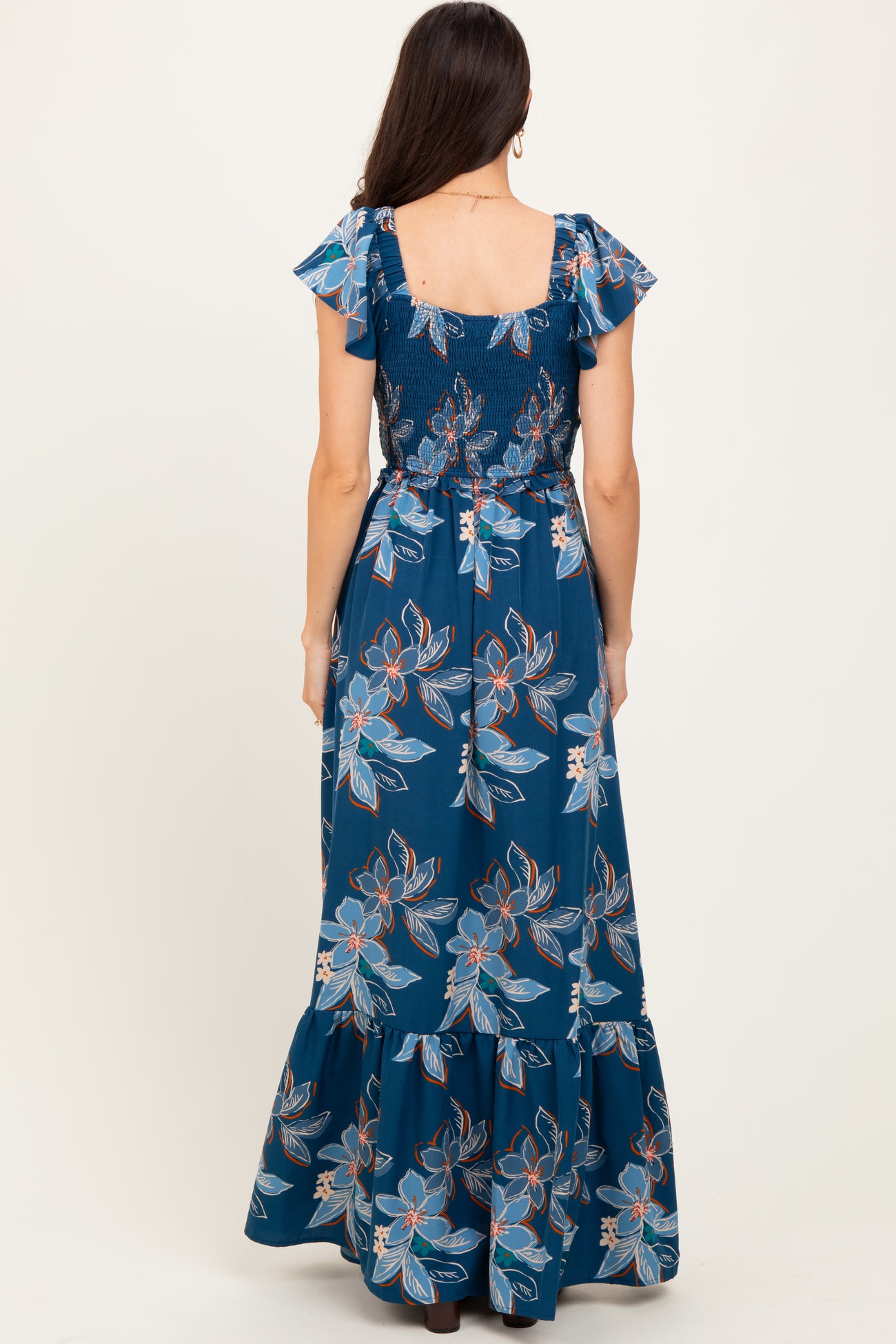 woman wearing a blue floral maxi dress with ruffled sleeves and a smocked back detail