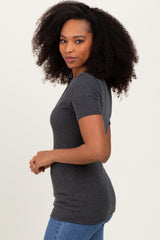 woman wearing a charcoal gray ribbed short sleeve top with fitted style and standing sideways against a plain background