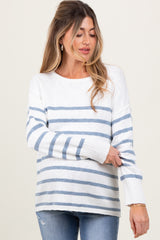 woman wearing a white and light blue striped maternity sweater with long sleeves and a relaxed fit
