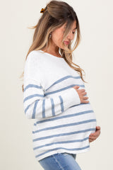 woman wearing a white and blue striped maternity sweater and holding her baby bump