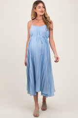 woman wearing a light blue pleated maternity dress with a tie waist and a visible baby bump