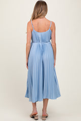 woman wearing a light blue maternity midi dress with pleated detailing and adjustable straps