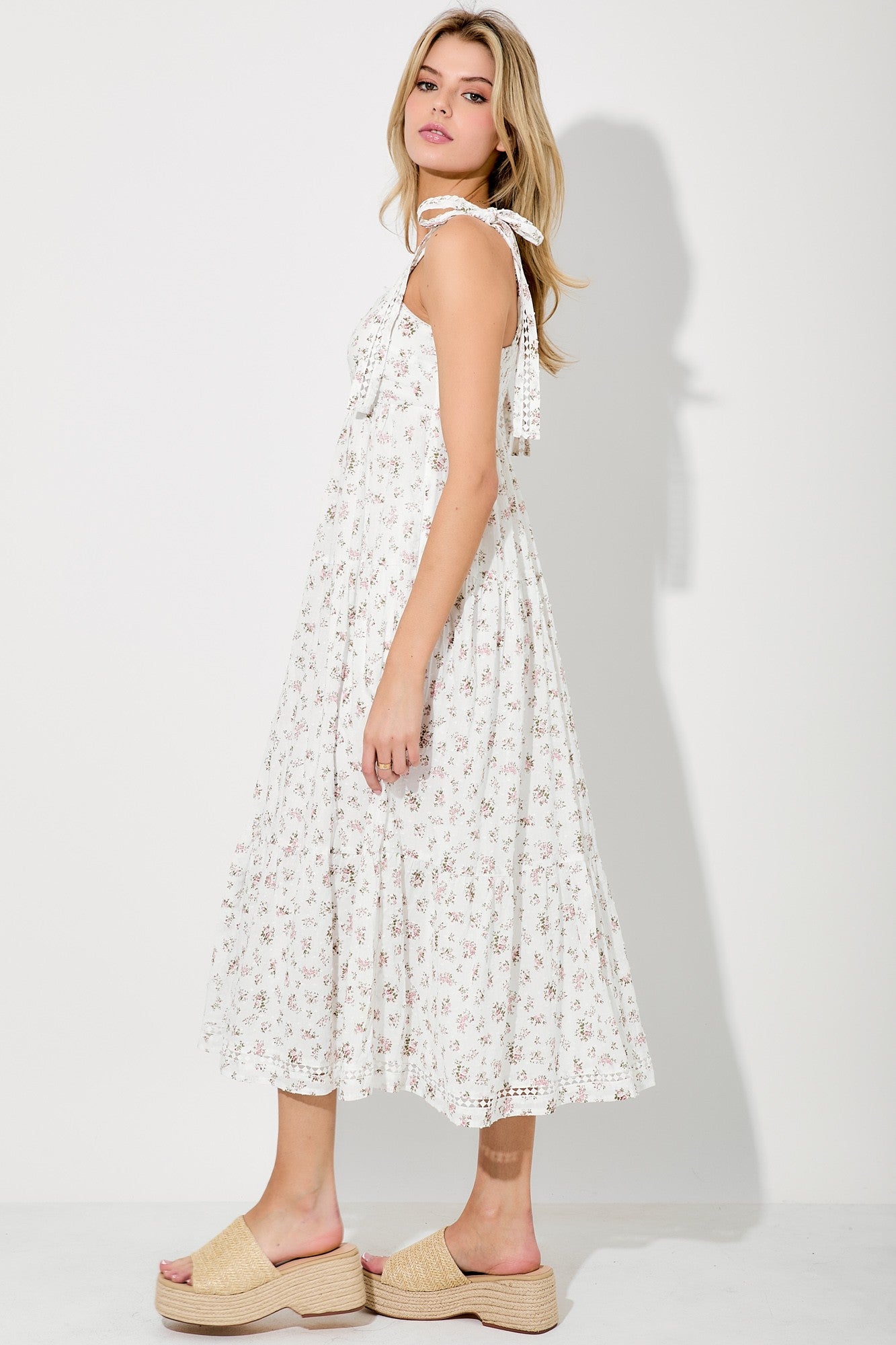 woman wearing a white floral midi dress with tie straps and tan platform sandals