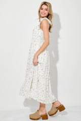 woman wearing a white floral midi dress with tie straps and a flowy silhouette, standing sideways