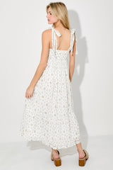 woman wearing a white floral maxi dress with adjustable tie straps and a keyhole back detail