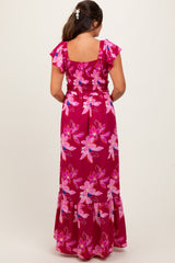 woman wearing a floral print pink maternity maxi dress with short ruffled sleeves and a smocked bodice, showing baby bump
