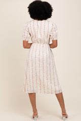 woman wearing a floral print midi dress with puff sleeves and a cinched waist, seen from the back