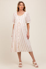 woman wearing a floral print maternity dress with puff sleeves and a button-down front, standing on a neutral background