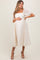 woman wearing a white floral embroidered maternity dress with puff sleeves and a visible baby bump