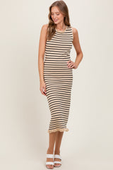 woman wearing a beige and black striped sleeveless midi dress with a ruffled hem and white block heels