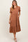 woman wearing a brown plaid tiered midi dress with short puff sleeves and side pockets