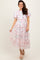 woman wearing a floral tiered maxi dress with short sleeves and a cinched waist, standing in front of a neutral background