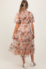 woman wearing a floral maternity maxi dress with tiered ruffles and short sleeves, showing her baby bump from the back