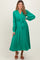 woman wearing a green button-up maternity dress with a tie waist and long sleeves, showing a baby bump
