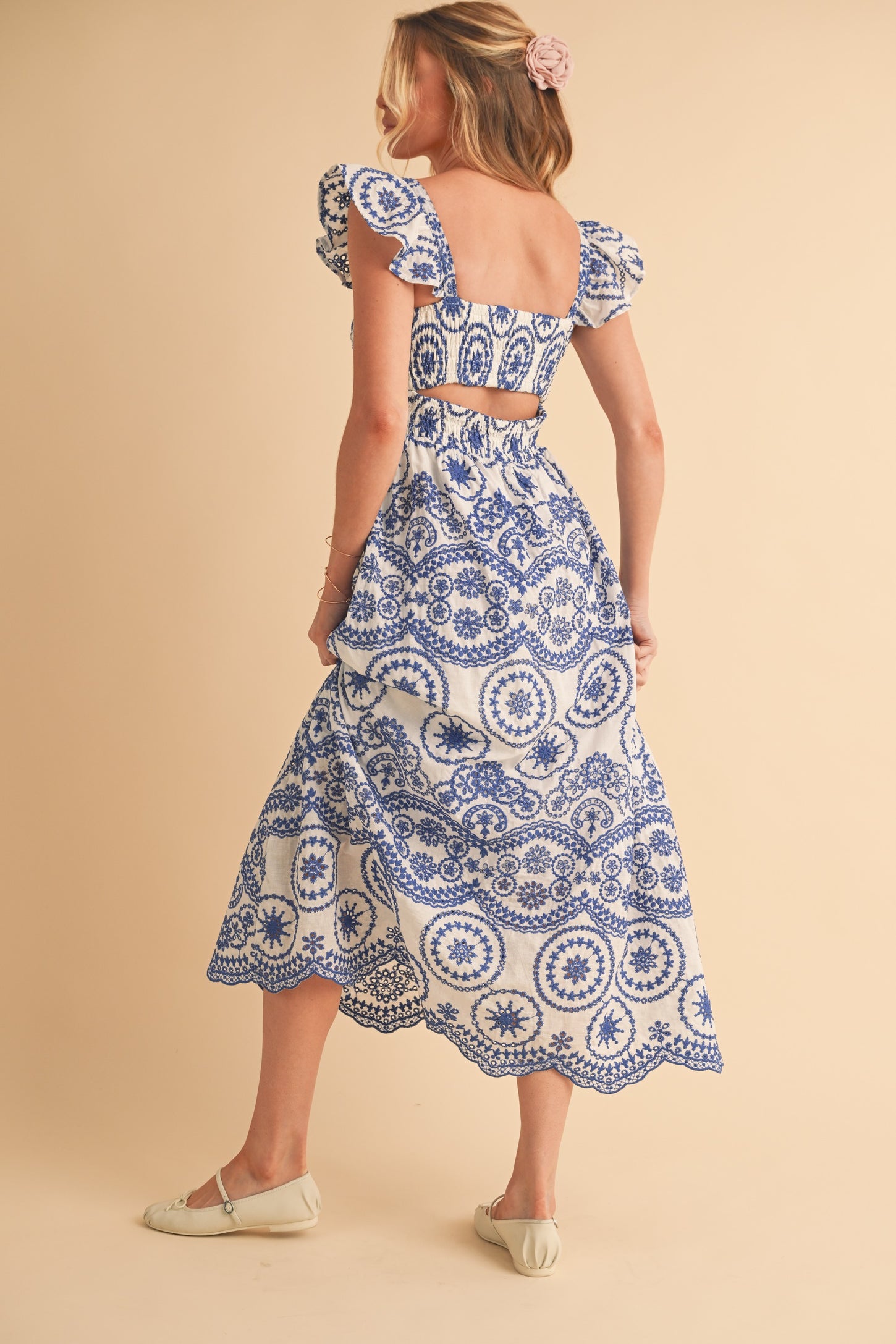 woman wearing a blue and white patterned two-piece dress with puff sleeves and a flowy skirt