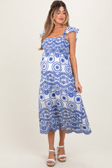 woman wearing a blue and white patterned maternity dress with ruffled sleeves and a baby bump visible