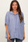 woman wearing a light blue striped maternity top with a button-down front and relaxed fit