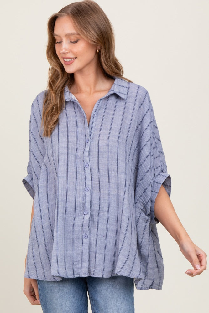 woman wearing a light blue striped button-up shirt with rolled sleeves and a relaxed fit