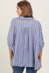 woman wearing a blue striped oversized blouse with a relaxed fit and back pleat detail