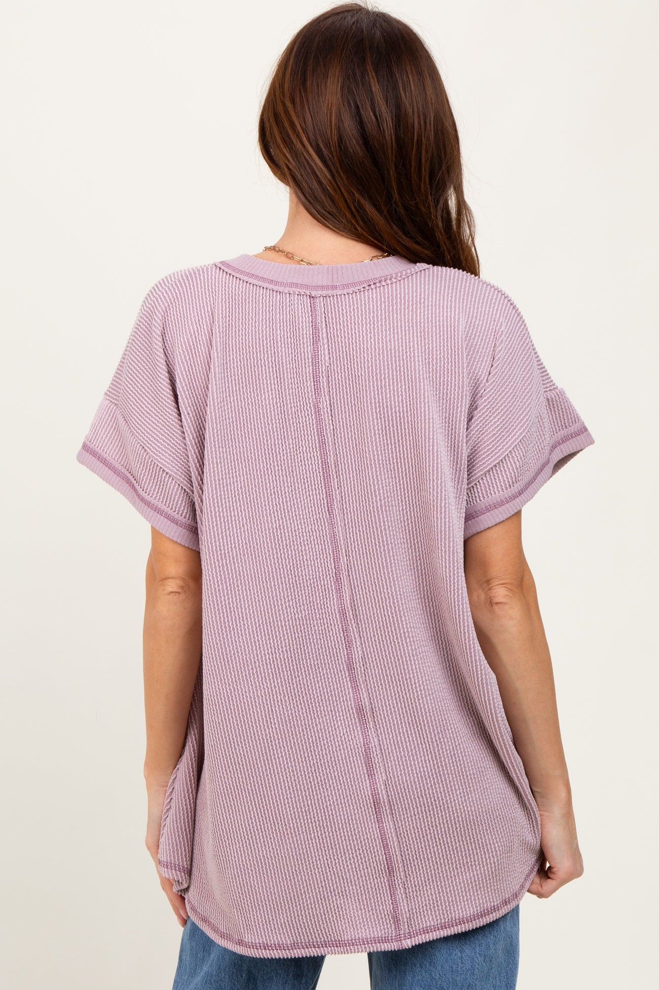 woman wearing a light purple short sleeve oversized top with a textured fabric and a center seam detail