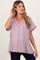 woman wearing a light mauve maternity top with a v-neck and short sleeves