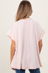 woman wearing a pink striped maternity top with short sleeves, shown from the back