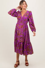 woman wearing a purple floral maternity dress with a smocked waist and long sleeves