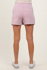woman wearing light pink maternity shorts with an elastic waistband, shown from the back