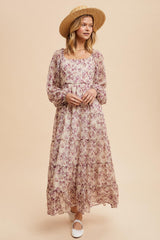 woman wearing a long floral maxi dress with long sleeves and a square neckline, paired with a straw hat