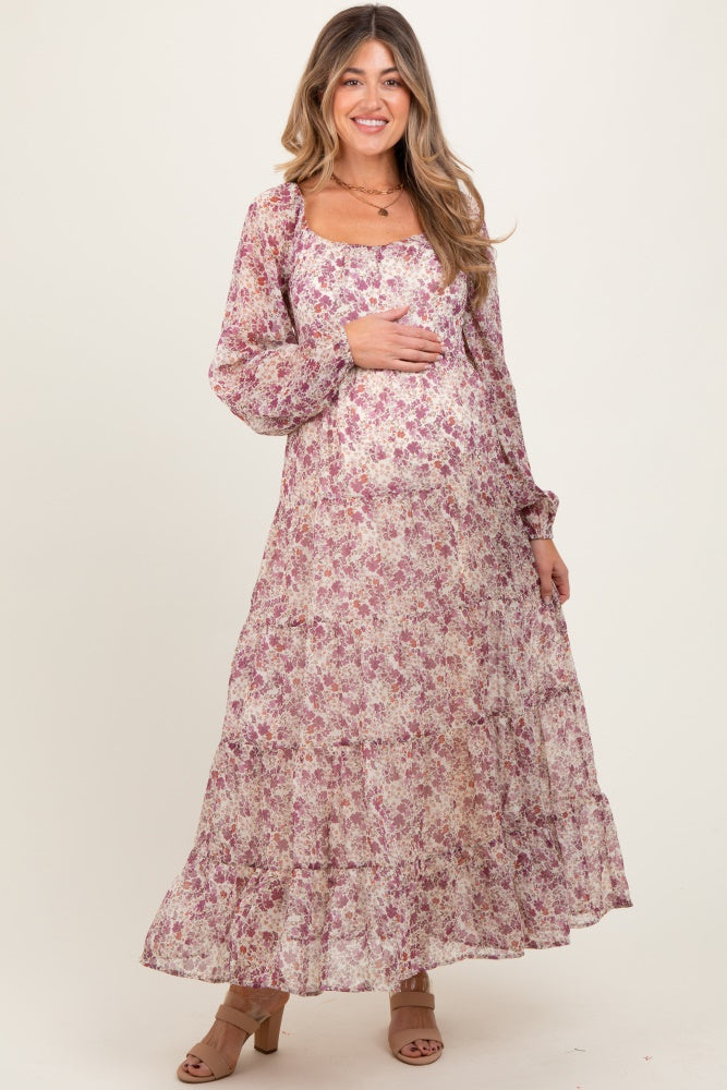 woman wearing a long sleeve floral maternity dress and holding her baby bump